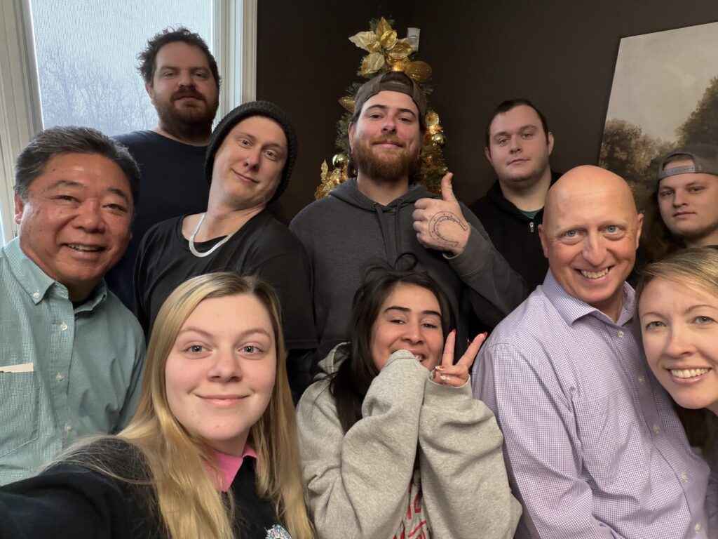 A photo of the A-1 team, smiling in front of a Christmas tree.